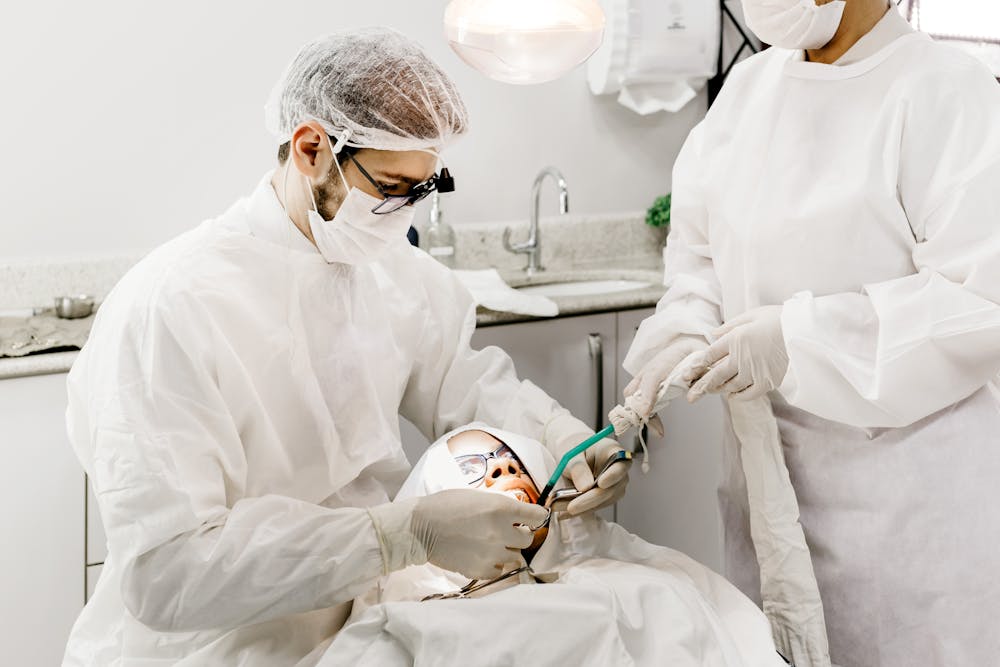 Anonymous dentist with assistant treating teeth of patient