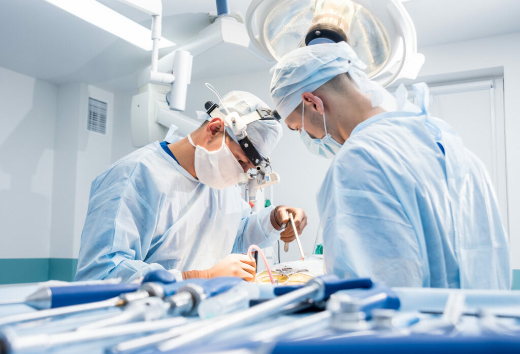 Spinal surgery. Group of surgeons in operating room with surgery equipment. Laminectomy. Modern medical background